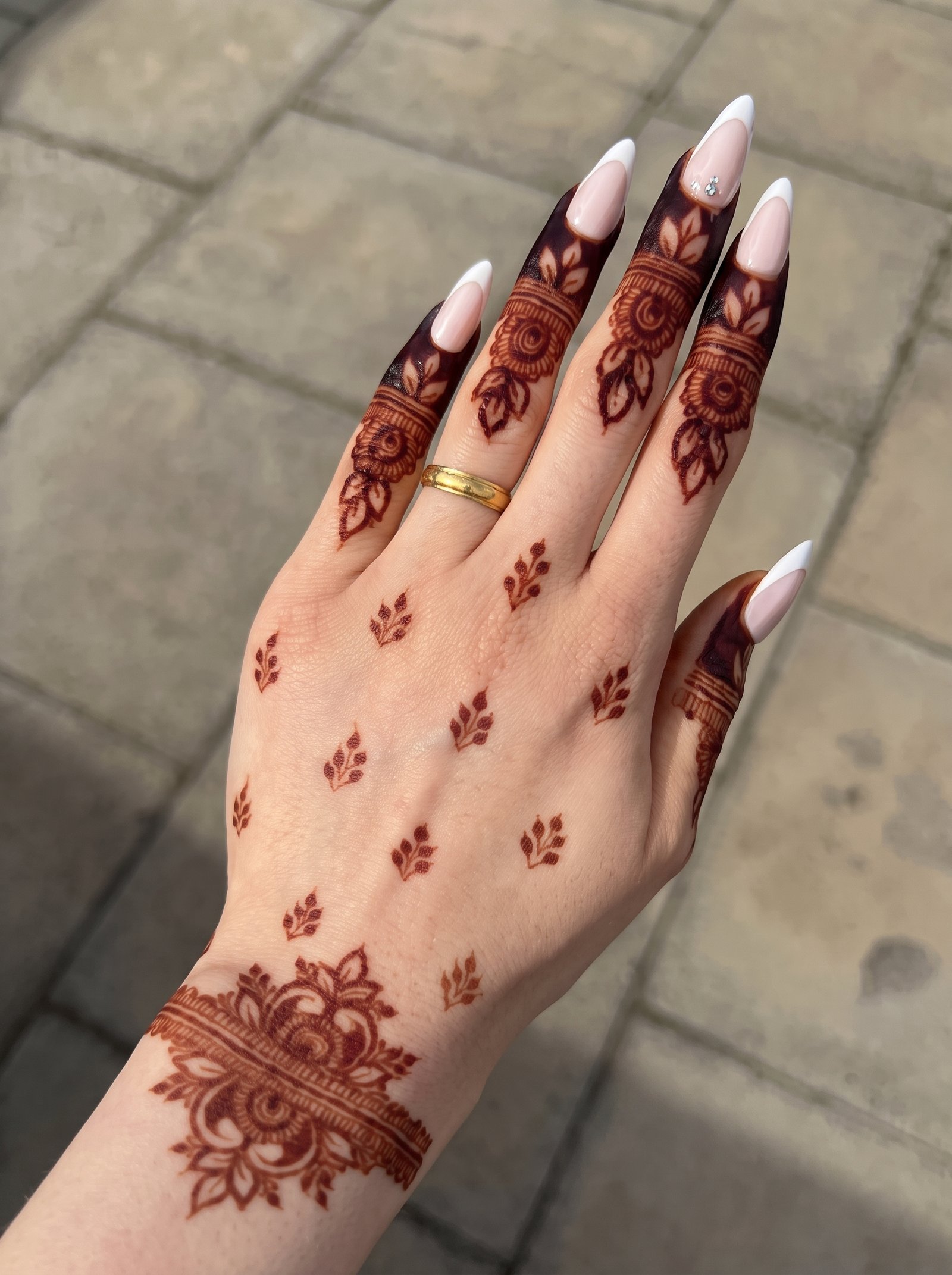 Minimal mehndi design with floral finger bands, leafy hand motifs, and a detailed floral wrist band