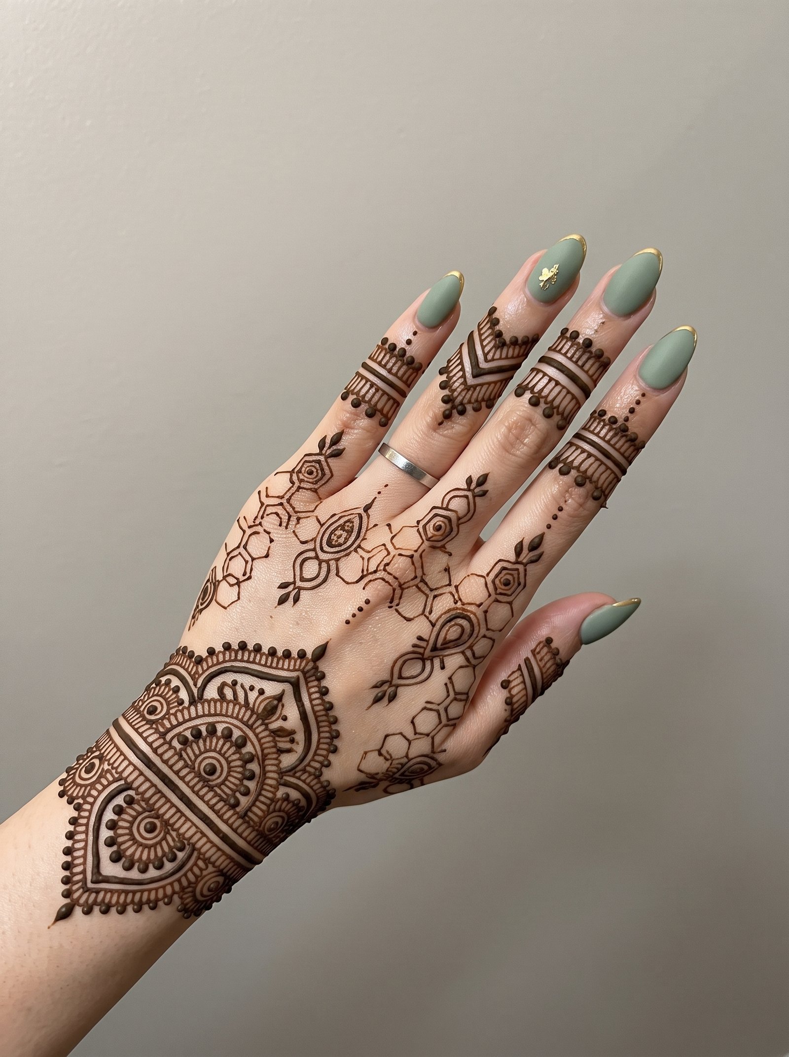 Minimal modern mehndi design with geometric floral patterns on hand
