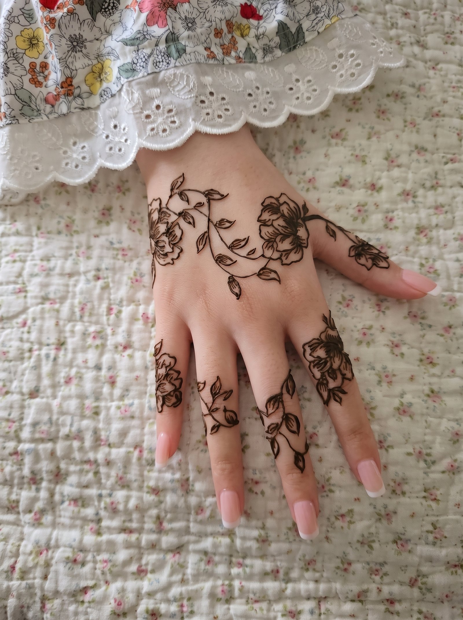 Back hand mehndi design featuring floral patterns, leafy vines, and elegant finger detailing in a minimalist style.