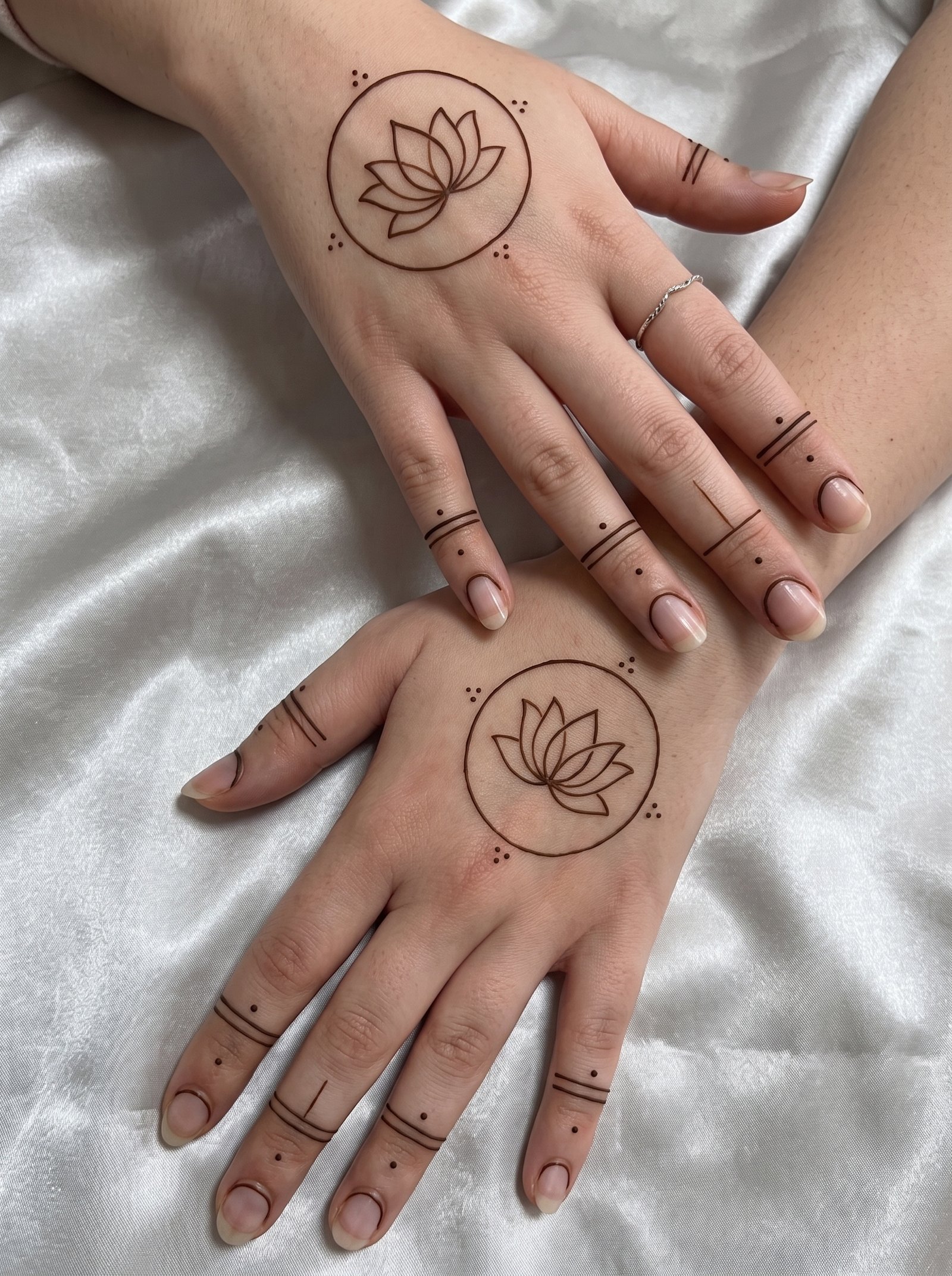 Simple mehndi design featuring a delicate lotus inside a circle with minimal finger lines and dotted details.