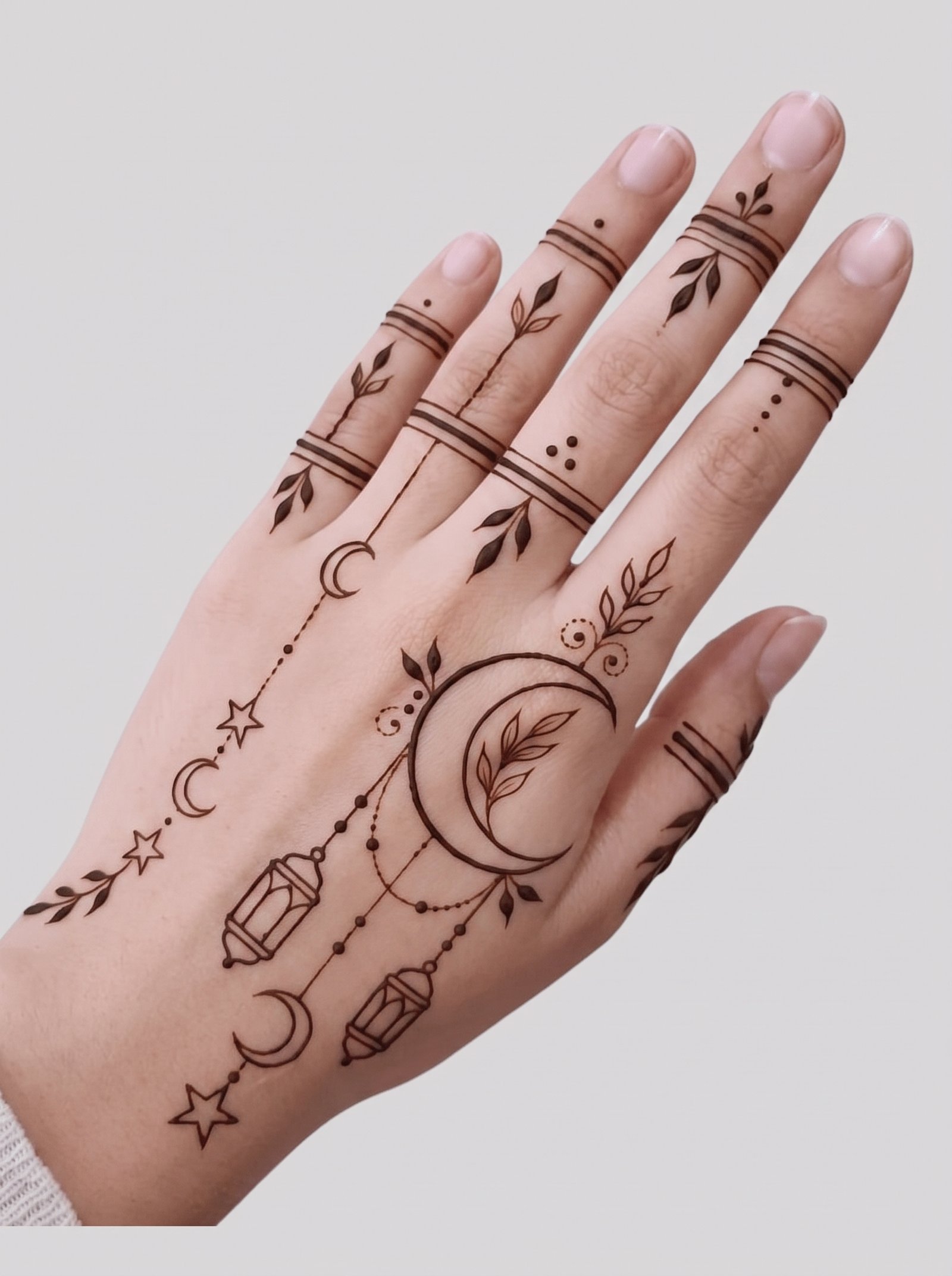Elegant Eid mehndi design featuring crescent moons, stars, hanging lanterns, leafy vines, and delicate finger patterns.