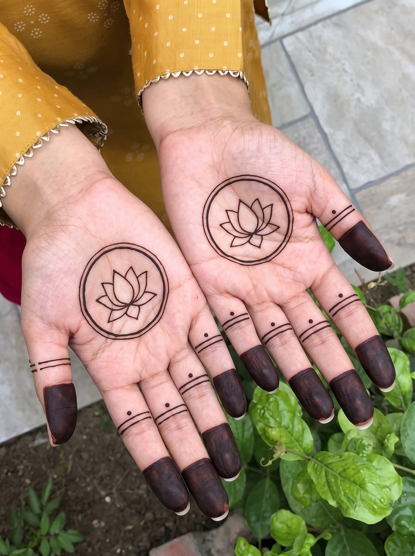 Beautiful Indian mehndi design featuring lotus motifs, circular patterns, dotted details, and dark finger tips.