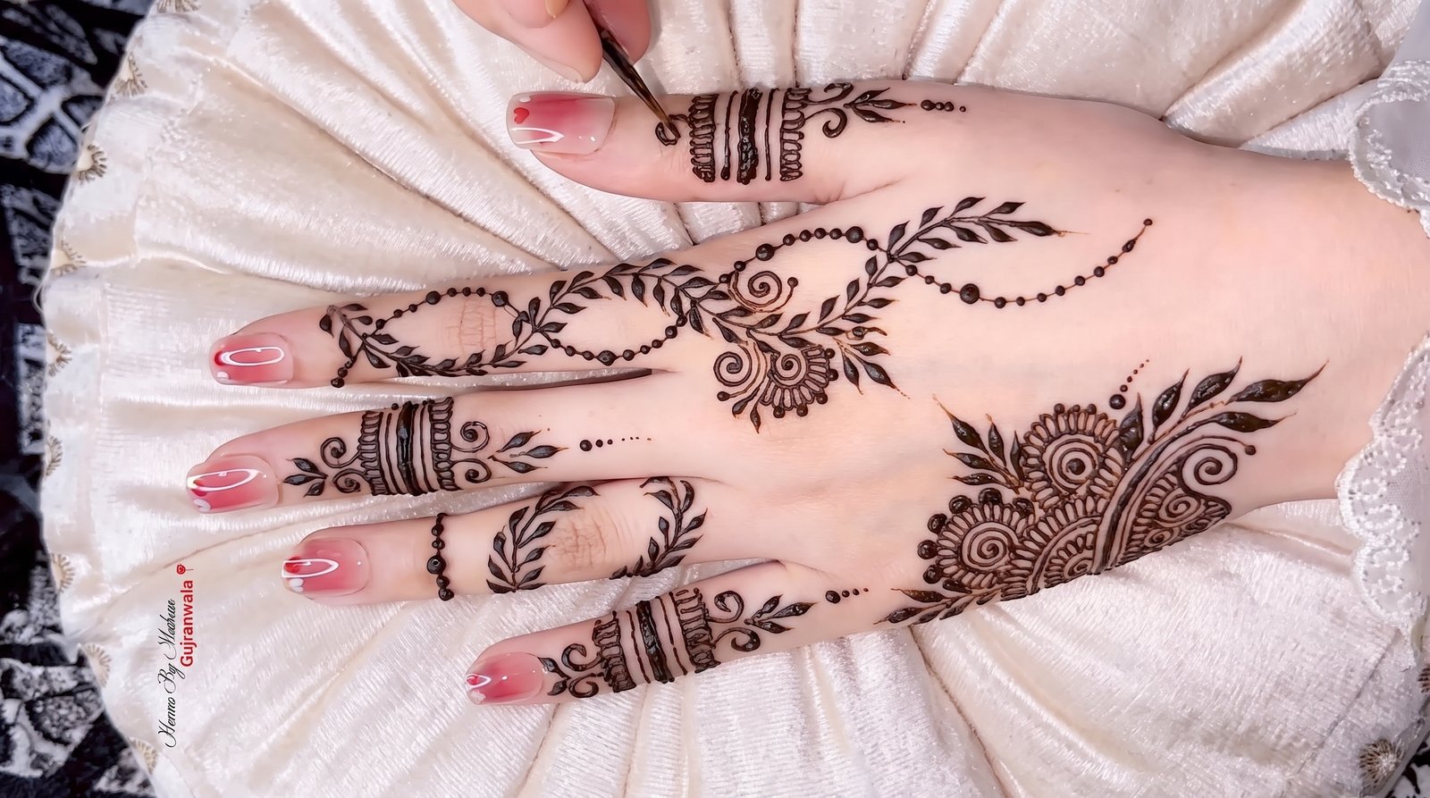 Elegant finger mehndi design featuring floral motifs, leafy vines, spiral details, dotted patterns, and decorative bands on the fingers.
