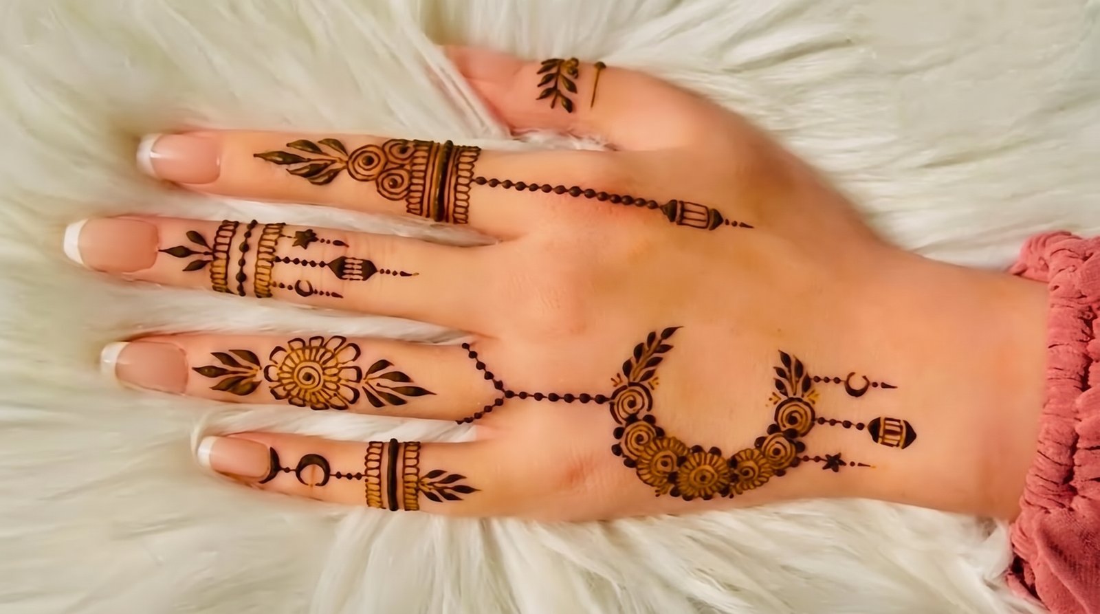 Elegant Eid mehndi design with floral motifs, leafy patterns, dotted chains, crescent moons, and decorative finger details.